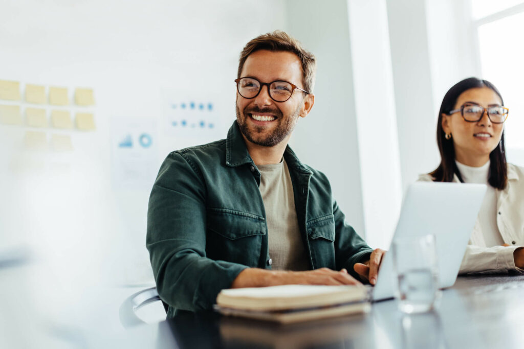 Smiling man on laptop in office